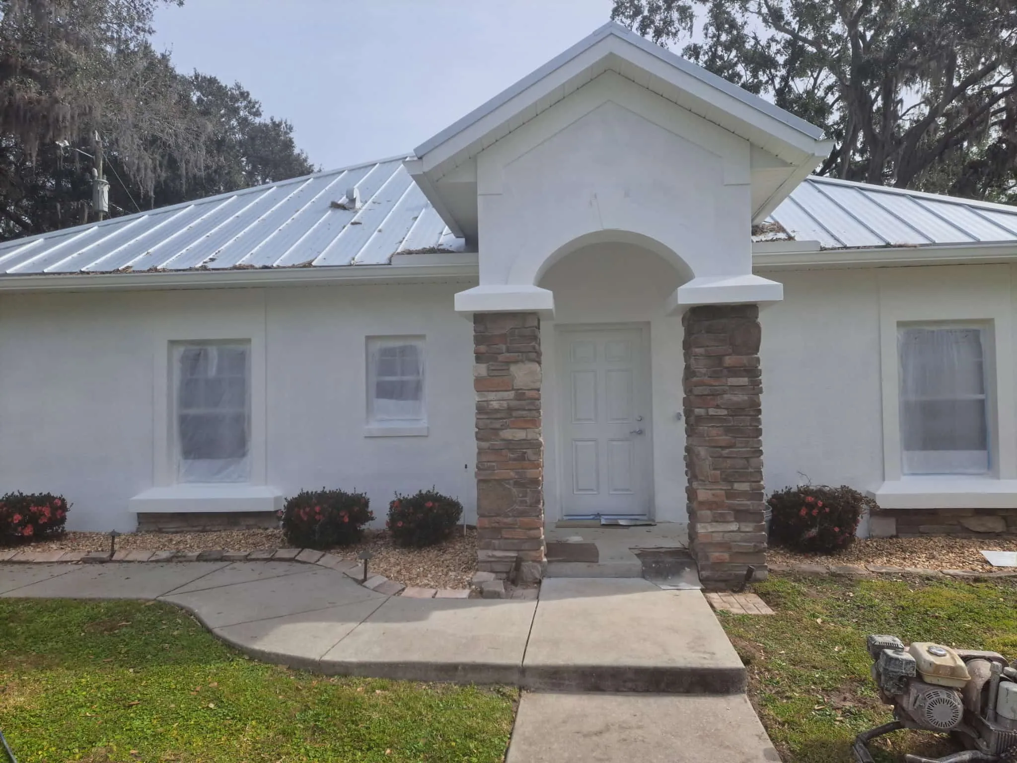 Before exterior home coating project showing faded white stucco in Orlando Florida