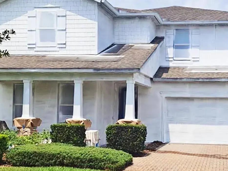Before exterior coating project showing faded white home in Central Florida